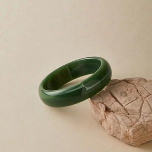 Bohemian dark green acrylic bangle with marbled semi-circle design on natural stone