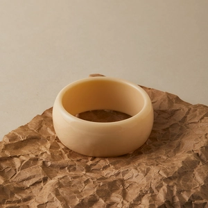 Gros plan d'un large bracelet en résine acrylique crème avec finition brillante chic