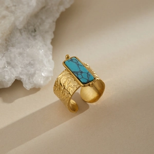 Macro view of wide gold ring with hammered texture and rectangular blue turquoise stone