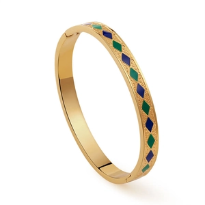 Dettaglio del bracciale in acciaio dorato vintage con intarsi in smalto e turchese