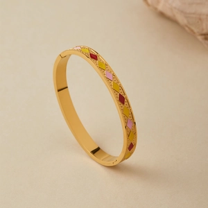 Dettaglio del bracciale in acciaio dorato con motivi a trama di diamante colorati