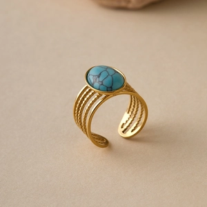 Macro detail of gold vintage ring with oval turquoise stone and multi-layered band