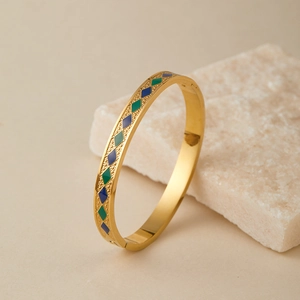 Dettaglio del bracciale dorato in acciaio inossidabile con motivi rombi in smalto