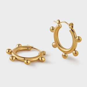 Dettaglio di orecchini a cerchio spessi placcati oro 18K con sei perle dorate decorative