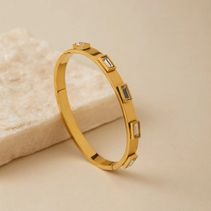 Dettaglio del bracciale rigido in oro opaco con zirconi rettangolari incastonati