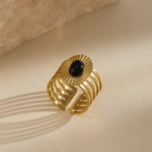 Detailed close-up of a vintage gold ring featuring a black stone and sunburst engraving