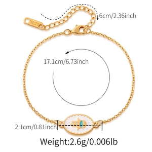 Detail of gold stainless steel bracelet with Hamsa Hand charm and blue gemstone inlay