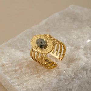 Detailed macro view of vintage gold ring featuring a grey stone on a white crystal rock