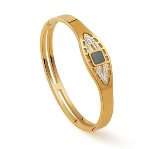 Dettaglio del bracciale rigido in acciaio dorato con pietra quadrata e accenti di strass