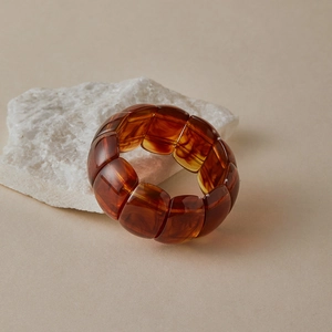 Macro shot of amber resin beaded bracelet showing smooth gradient texture and polished finish