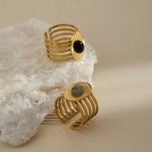 Close-up of vintage gold stainless steel rings with black and marble oval stone details