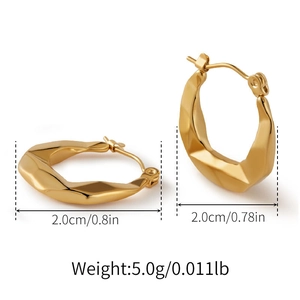 Dettaglio di orecchini geometrici intrecciati in oro con diametro 2 cm e finitura lucida