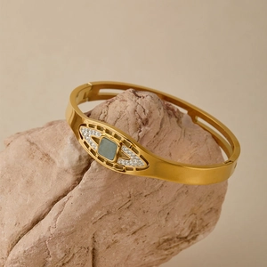 Dettaglio del bracciale in acciaio dorato con pietra turchese quadrata e accenti in pavé