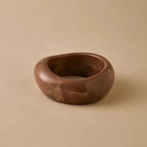 Macro detail of tortoiseshell acrylic bangle with irregular marbled resin texture