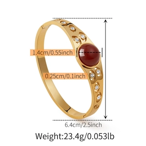 Dettaglio del bracciale rigido vintage dorato in acciaio inossidabile con pietra rossa