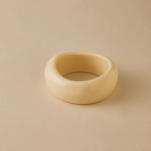 Detail view of chunky cream resin bangle featuring a smooth polished minimalist surface