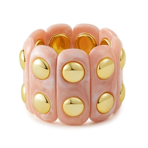 Détail du bracelet élastique en résine marbrée rose avec clous dorés élégants