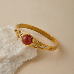 Dettaglio del bracciale vintage in acciaio dorato con pietra rossa e zirconi incastonati