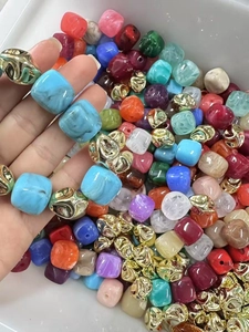 Gros plan de perles en résine marbrée colorées et de perles d'espacement dorées pour bijoux