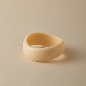 Detail view of cream acrylic irregular bangle with marble texture and polished finish