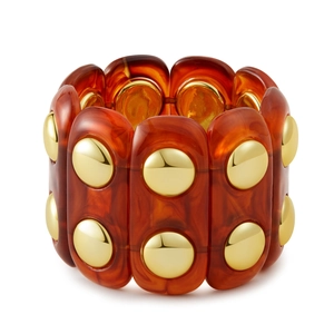 Dettaglio di bracciale elastico in acrilico ambrato con rivetti in metallo dorato lucido