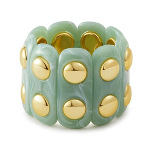Dettaglio di un bracciale elastico largo in resina verde marmorizzata e borchie oro
