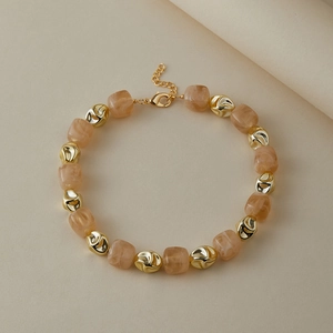 Dettaglio della collana di perle con accenti dorati e perline di resina rosa