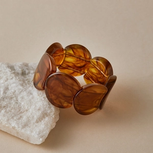 Gros plan de perles de bracelet en acrylique ambré montrant des motifs naturels d'écaille