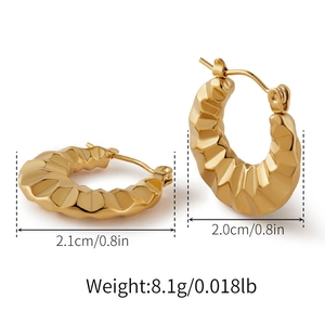 Dettaglio di orecchini a cerchio dorati chunky con texture geometrica sfaccettata