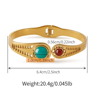 Dettaglio del bracciale rigido dorato con turchese, pietra rossa e trama a foglia