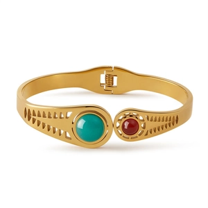 Dettaglio del bracciale dorato con inserti in turchese e pietra color rubino