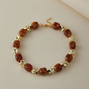 Dettaglio di perline in resina retrò e perle dorate irregolari su una collana di perline