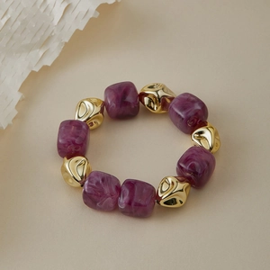 Détail de perles cubiques en résine marbrée violette et perles dorées sur le bracelet