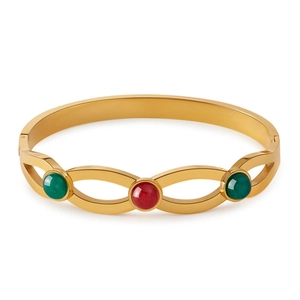 Dettaglio del bracciale in acciaio dorato con pietre di turchese verdi e rosse