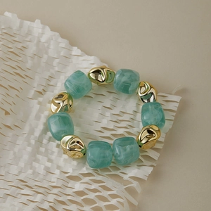 Bracelet moderne en résine marbrée vert menthe avec des perles en métal doré irrégulier