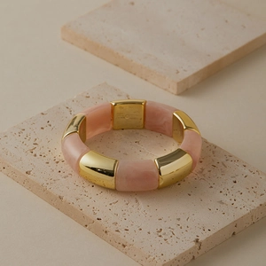 Bracelet élastique en résine marbrée rose et segments en métal doré poli