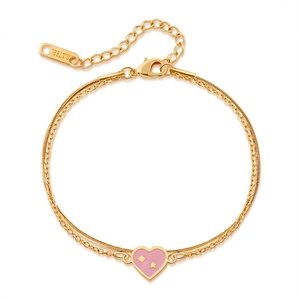 Detail of gold double-layer chain bracelet with pink heart and star charms