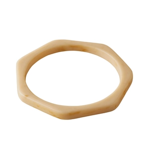 Detail of a geometric hexagonal resin bangle with a beige marble texture pattern