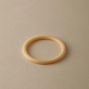 Minimalist creamy acrylic bangle with smooth circular design and warm glossy finish