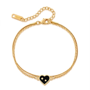 Detail of gold stainless steel double chain with black heart charm and lobster clasp