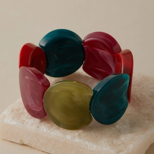 Détail du bracelet en résine marbrée avec perles géométriques irrégulières rouges et vertes