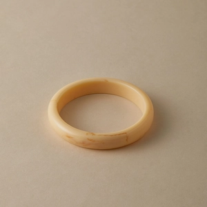 Macro view of creamy white acrylic bracelet with orange-brown marble texture