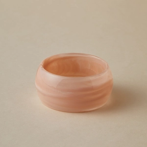 Détail d'un large bracelet en résine avec texture marbre rose et finition polie