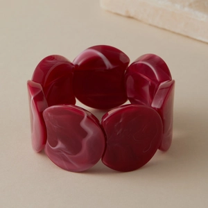 Gros plan sur le bracelet en résine marbrée rouge avec perles acryliques à motifs tourbillons