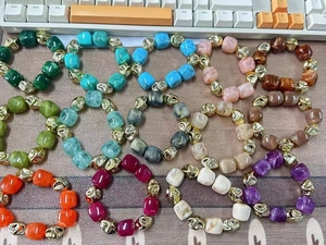 Vue à plat de bracelets colorés en résine avec motifs marbrés et entretoises dorées irrégulières