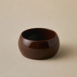 Vue détaillée du large bracelet en résine marron foncé avec une finition miroir polie