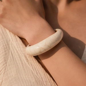 Close-up van crème beige hars armband met marmeren textuur om de pols