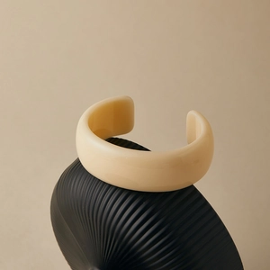Minimalist ivory resin open wide cuff bracelet with smooth finish on a stylish black base