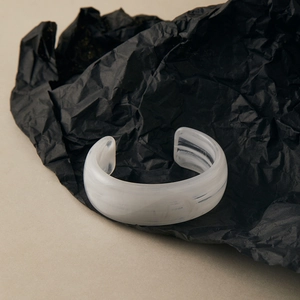 Detailed view of white marble acrylic cuff bracelet with translucent resin texture