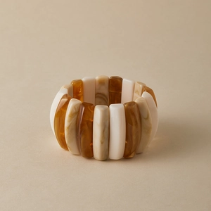 Detail view of the wide elastic resin bracelet with amber marble and cream beads